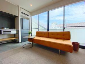 a living room with a couch and some windows at Joka Base in Kakegawa