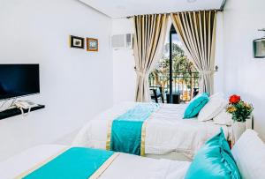 1 dormitorio con 2 camas y TV en RedDoorz at PWL Exclusive Resort Cebu en Carmen