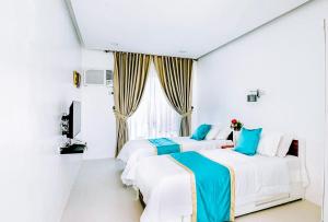 2 camas en una habitación blanca con ventana en RedDoorz at PWL Exclusive Resort Cebu en Carmen