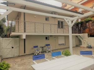 a patio with chairs and a table and a house at Spitaki Apartments Potos in Potos