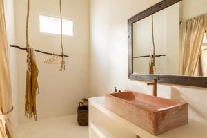 ein Badezimmer mit einem hölzernen Waschbecken und einem Spiegel in der Unterkunft Villa Ores Bali in Canggu