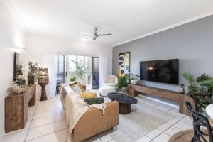 a living room with a couch and a tv at Afternoon Delight in Cairns