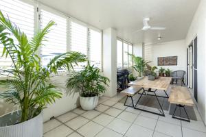 una habitación con macetas, mesa y sillas en Afternoon Delight, en Cairns