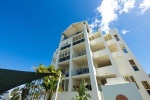 Un edificio blanco con un cielo azul al fondo. en Afternoon Delight, en Cairns