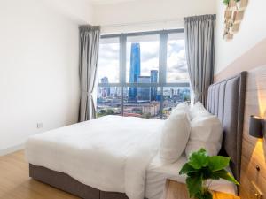 a bedroom with a large bed with a large window at Greystone Continew Residensi in Kuala Lumpur