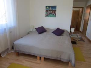 ein Schlafzimmer mit einem großen Bett mit lila Kissen in der Unterkunft Haus Grete in Langenargen