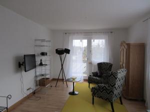 ein Wohnzimmer mit einem Stuhl und einem TV in der Unterkunft Haus Grete in Langenargen