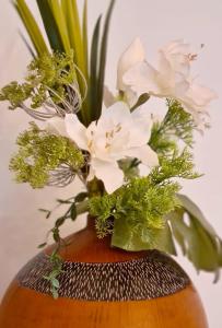 um vaso com flores brancas sobre uma mesa em Anavai apartment em Papeete