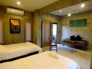 una camera d'albergo con due letti e un divano di BEACHWAY APARTMENT a Ban Lamai