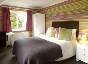 A bed or beds in a room at Charlton Kings Hotel 