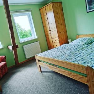 a bedroom with a bed and a window at Ferienhof Stobbe Fewo Heuboden in Grube