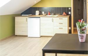 a kitchen with a white refrigerator and a table at Nice Studio In Borcz With Kitchen in Borcz