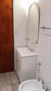 a white bathroom with a sink and a mirror at APART CENTRO RIOJA, Zona Residencial, Parking privado gratis a 100 mts in Mendoza