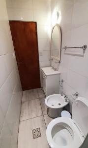 a bathroom with a toilet and a sink and a mirror at APART CENTRO RIOJA, Zona Residencial, Parking privado gratis a 100 mts in Mendoza