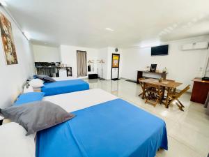 2 Betten in einem Zimmer mit einem Tisch und einem Esszimmer in der Unterkunft J&D Lodge in Papeete