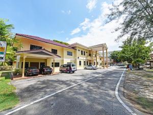 budynek z samochodami zaparkowanymi przed nim w obiekcie Super OYO Capital O 90434 Marmoris House w mieście Kuala Terengganu