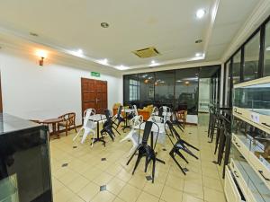 um restaurante com cadeiras e mesas num quarto em Super OYO Capital O 90434 Marmoris House em Kuala Terengganu