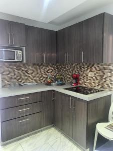 a kitchen with wooden cabinets and a red sink at Sea breeze vacation lll en Condominio Verde mar in San Juan