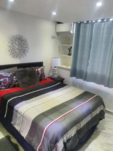 um quarto com uma cama e uma janela em Sea breeze vacation lll en Condominio Verde mar em San Juan