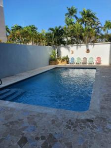 a swimming pool in a backyard with chairs and trees at Sea breeze vacation lll en Condominio Verde mar in San Juan