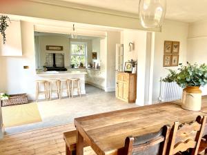 a kitchen and dining room with a wooden table at Highview House Norfolk Coast - seaviews, beach, hot tub in Mundesley