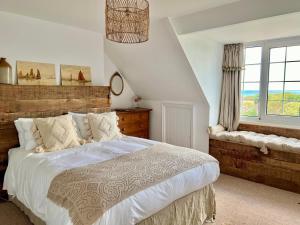 a bedroom with a large bed and a window at Highview House Norfolk Coast - seaviews, beach, hot tub in Mundesley