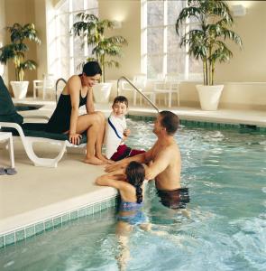 a family sitting in a swimming pool at Baymont by Wyndham Rolla in Rolla