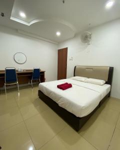 a bedroom with a bed with two chairs and a desk at D' Anjung Inn in Tangkak
