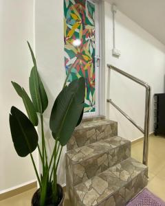a plant in a vase next to a staircase at D' Anjung Inn in Tangkak