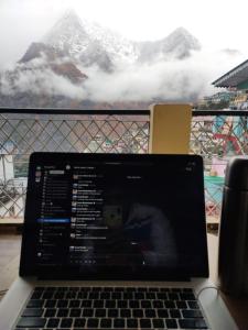 a laptop computer sitting on a table with a view of a mountain at Odyssey Stays Joshimath - Near Narsingh Temple in Joshīmath
