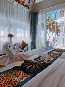 two swans made out of towels on beds in a bedroom at บรรเจิด วิลล่า บีช@สิชล in Ban Plai Thon