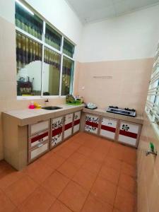 a kitchen with a sink and a counter top at D' Anjung Inn in Tangkak