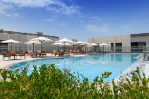 a large swimming pool with chairs and umbrellas at Le Mirage City Walk in Doha