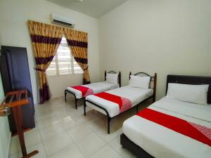 a room with two beds and a window at D' Anjung Inn in Tangkak