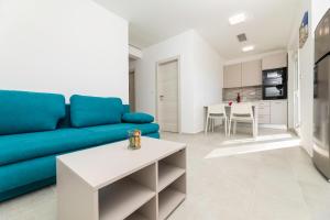 een woonkamer met een blauwe bank en een tafel bij Apartments Sucic 2 in Soline