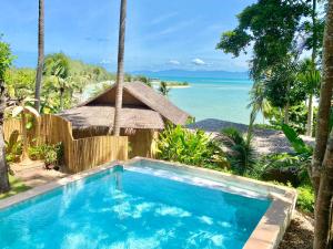 a swimming pool with a view of the ocean at Kalulushi Bungalows in Haad Pleayleam