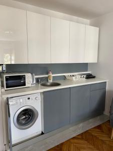 a kitchen with a washing machine and a microwave at Apartment Silver Pedestrian Zone in Belgrade
