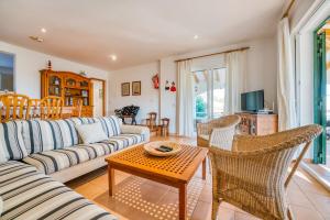 a living room with a couch and chairs and a tv at Villa Beatriz in Santo Tomás