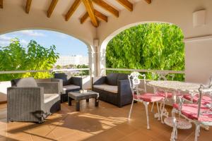 a patio with chairs and tables and windows at Villa Beatriz in Santo Tomás