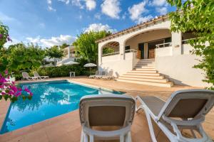 a villa with a swimming pool and two chairs at Villa Beatriz in Santo Tomás