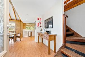 a kitchen and dining room with a desk and a staircase at Goanna Cottage - Woodstone Estate in Dunsborough