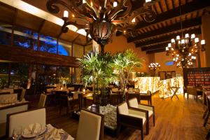 a dining room with tables and chairs and a chandelier at Hotel Gobernador in Durango