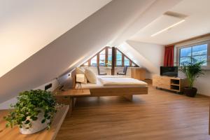een slaapkamer op zolder met een bed en een televisie bij Weisses Lamm in Hallstatt