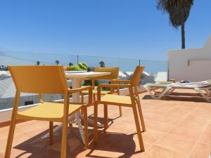 patio z krzesłami i stołem na balkonie w obiekcie Apartamentos Santa Rosa w Costa Teguise
