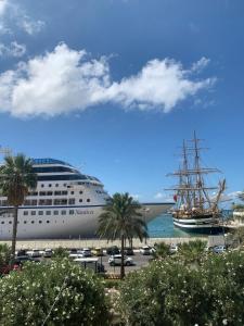 een cruiseschip aangemeerd in een haven met palmbomen bij Drepanon, prospettive sul mediterraneo B&B in Trapani