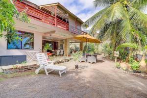a house with a white chair and an umbrella at Tahiti beach house in Arue
