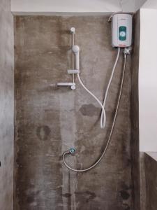 eine Dusche mit einem an der Wand befestigten Schlauch in der Unterkunft Palmera El Nido Inn in El Nido