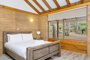 a bedroom with a bed and a large window at Possum Cottage - Woodstone Estate in Dunsborough