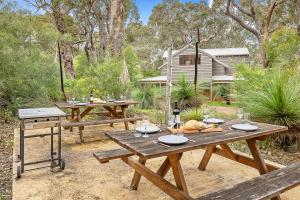 a picnic table in a yard with a grill at Possum Cottage - Woodstone Estate in Dunsborough