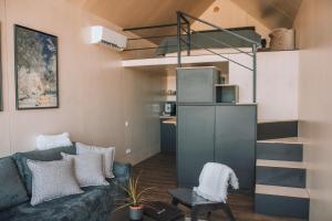 a living room with a couch and a kitchen at PullanHouse Laima - small and cosy lakeside holiday house in Alūksne